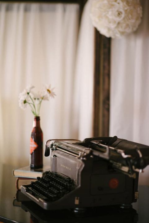 A vintage typewriter for guests to leave messages! | Milton Photography | See More: https://heyweddinglady.com/ruby-and-gray-wedding-with-vintage-book-details-from-milton-photography/