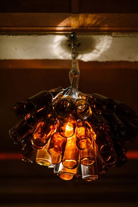 Who knew a beer bottle chandelier would be romantic? | Milton Photography | See More: https://heyweddinglady.com/ruby-and-gray-wedding-with-vintage-book-details-from-milton-photography/