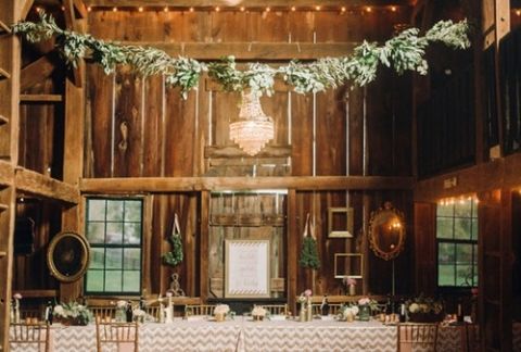 A Romantic Lodge Reception Hung with Chandeliers and Garlands of Greenery | Justin and Mary Photography | See More! https://heyweddinglady.com/down-the-garden-path-a-forest-green-and-peach-wedding/