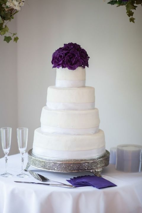 A Classically Elegant Wedding Cake topped with Purple Flowers | Craig Hodge Photography | See More! https://heyweddinglady.com/elegant-simplicity-in-royal-purple-from-craig-hodge-photography/