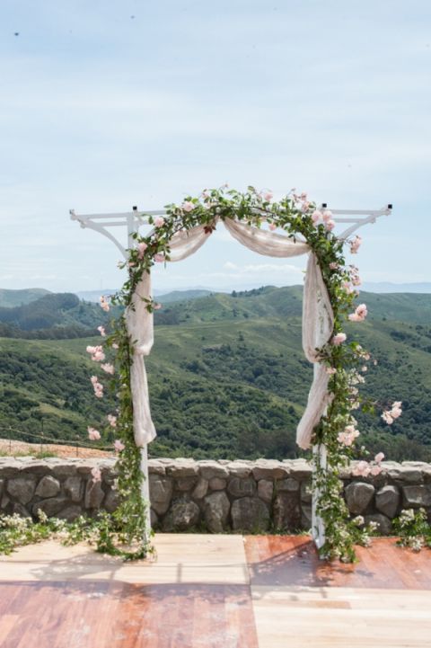 A Wedding Ceremony Arch of White Roses Overlooking the Mountains | Dawn Huemann Photography | See more! https://heyweddinglady.com/sweet-and-stylish-mountaintop-wedding-by-dawn-heumann-photography/