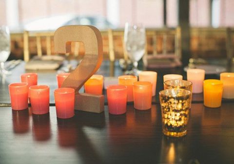 Vibrant Orange Votive Candles with Gold Table Numbers | Jason Hales Photography | See More! https://heyweddinglady.com/modern-art-nouveau-wedding-inspiration-glittering-gold-orange-blue/