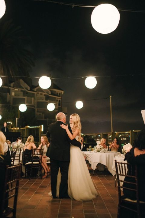 Hanging Lanterns over a Seaside Terrace Wedding Reception | Vitaly M Photography | Black Tie Coastal Wedding with Classic Beach Details