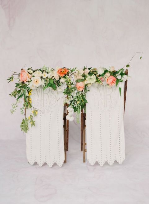 Flower Adorned Bride and Groom Chair Decor | Corbin Gurkin Photography | https://heyweddinglady.com/wild-heart-carefree-bohemian-wedding-peach-sage/