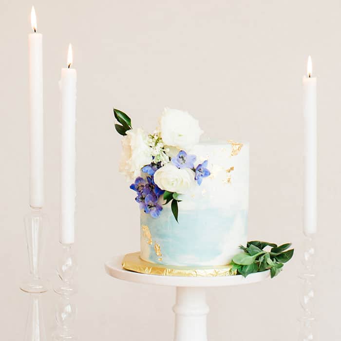 This is a handpainted watercolor cake with Prussian blue roses perfect for  a celebration!