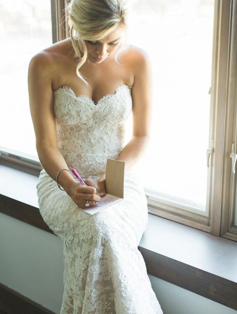 Bride in a Fitted Lace Wedding Dress Writing Her Vows