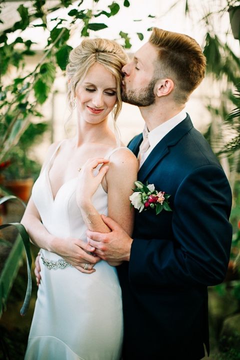 Bride and Groom Embracing in a Greenhouse