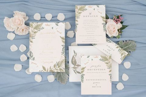 Floral wedding invitations on a dusty blue background