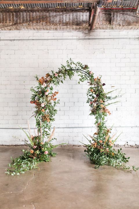 Industrial Farmhouse Ceremony with a Whitewashed Brick Backdrop and Fall Leaf Flower Arch
