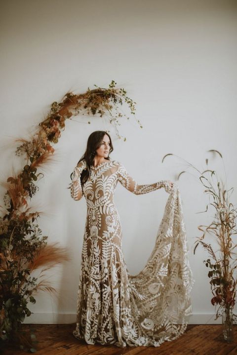 Indoor Fall Wedding Ceremony with a Foliage Arch and a Tattoo Lace Rue de Seine Dress