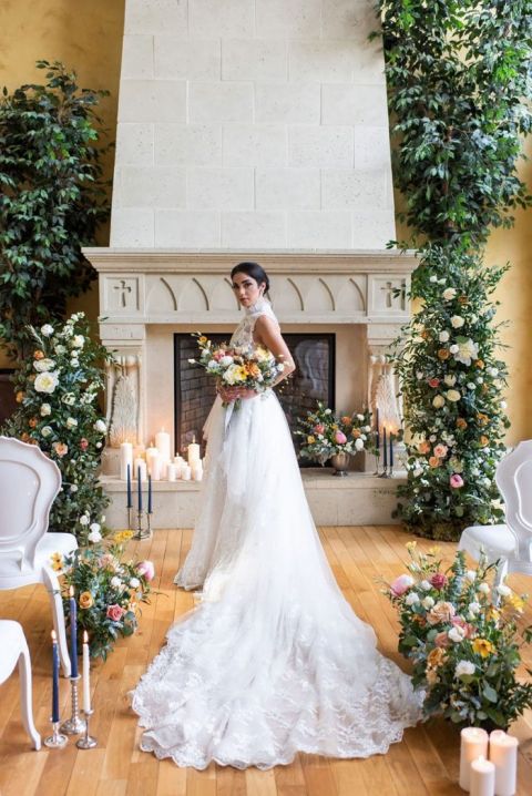 Cozy Indoor Castle Wedding Ceremony with Greenery and Candle Mantel Decor